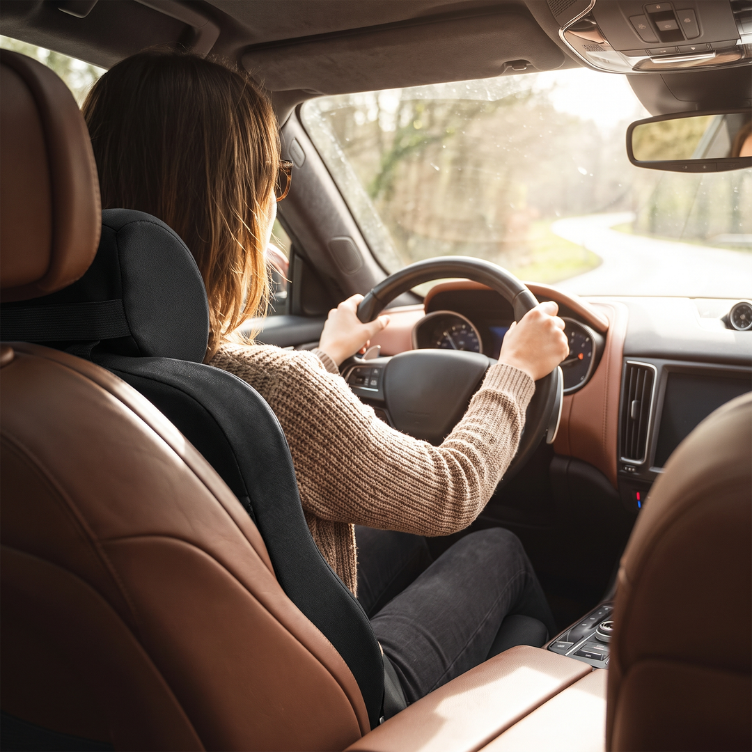 Person driving with black memory foam seat and lumbar cushion set installed