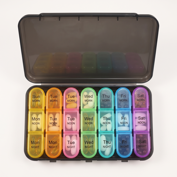 Top-down view of weekly pill organizer with compartments filled with vitamins