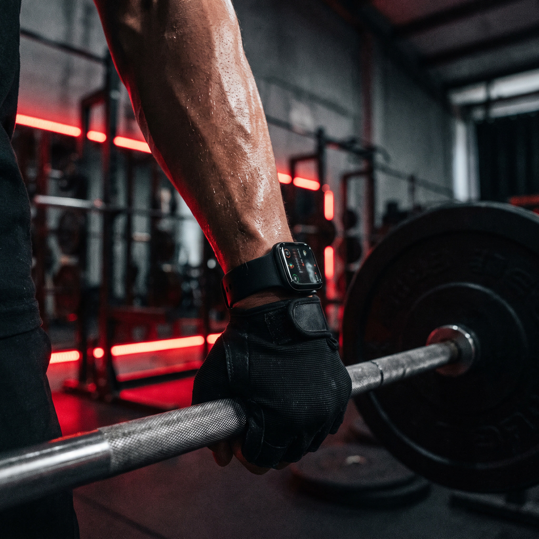 PHYSIOATHLETX smart fitness watch worn during a gym workout, black silicone band