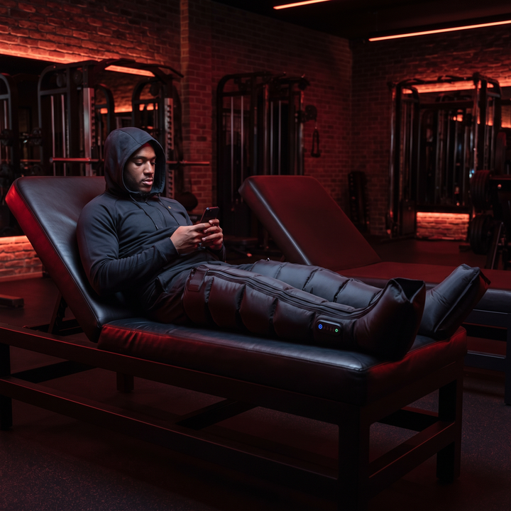 Athlete relaxing during a compression recovery session at the gym