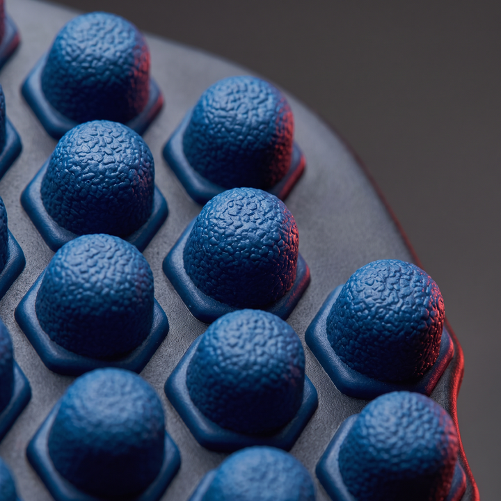 Close-up of textured peg surface on blue foot massage board