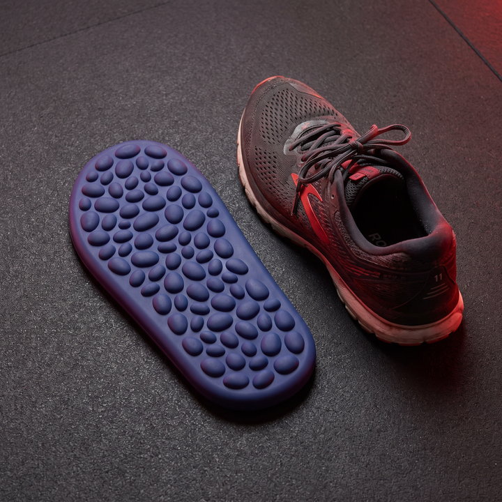 Blue foot massage board next to sneaker for size reference