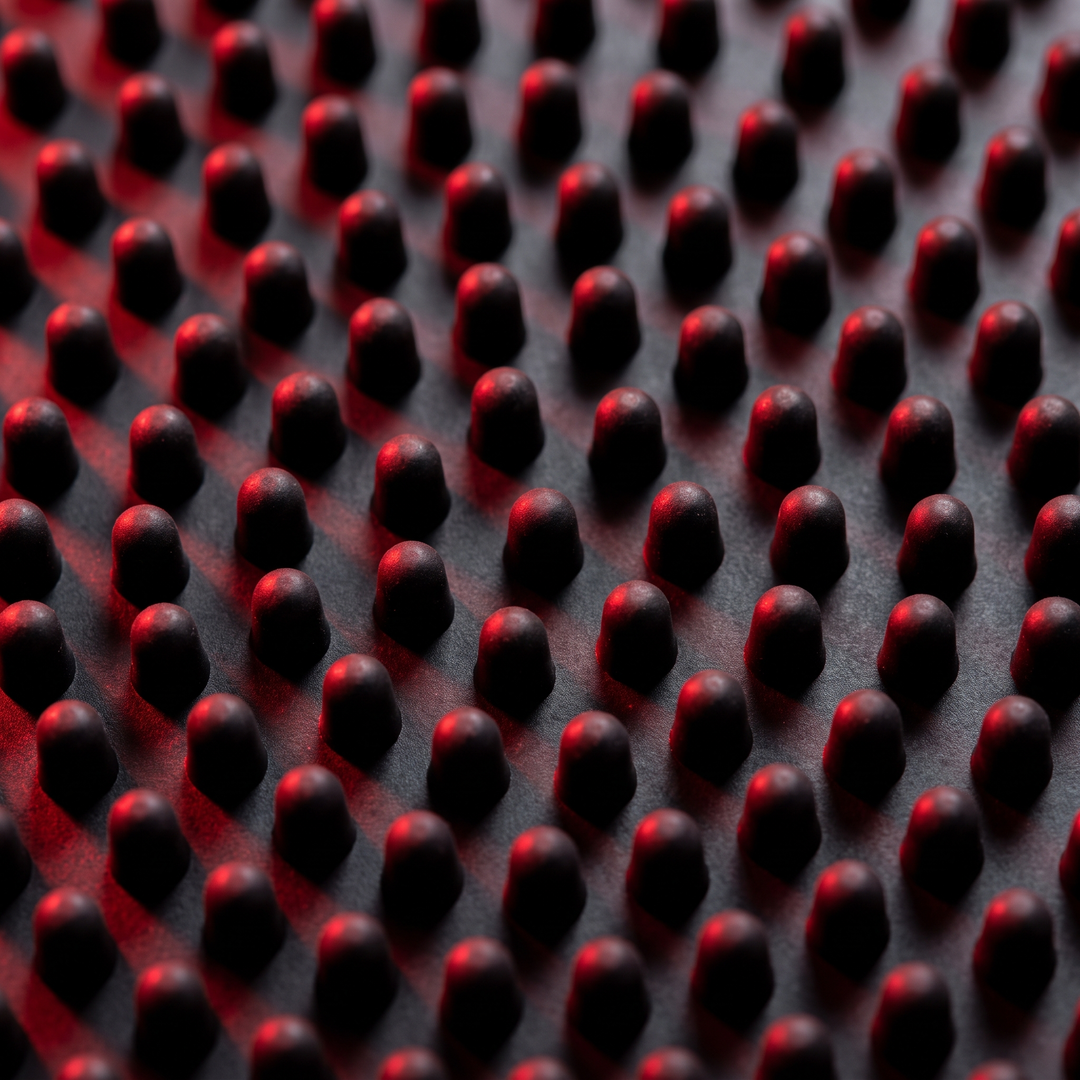 Detailed view of foot massage board peg pattern with dramatic lighting