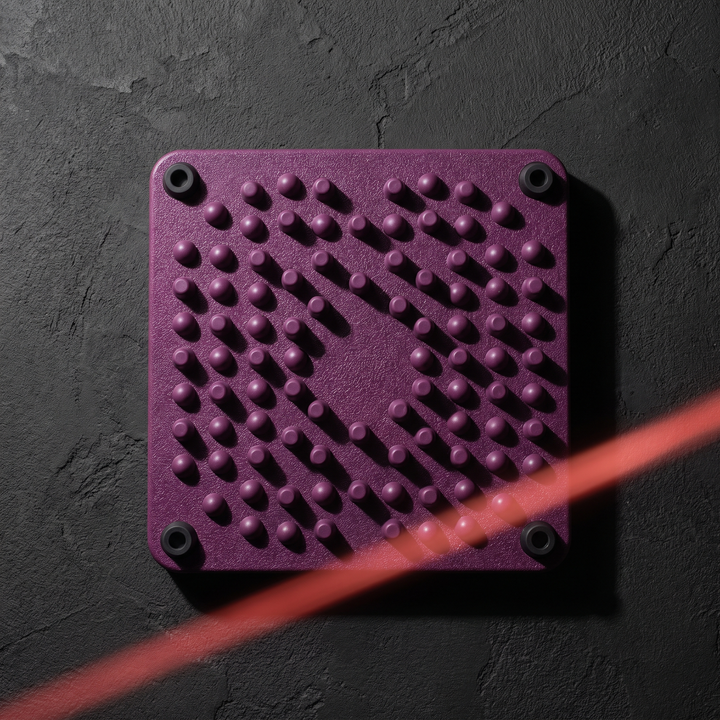 Top-down view of purple foot massage board on dark surface