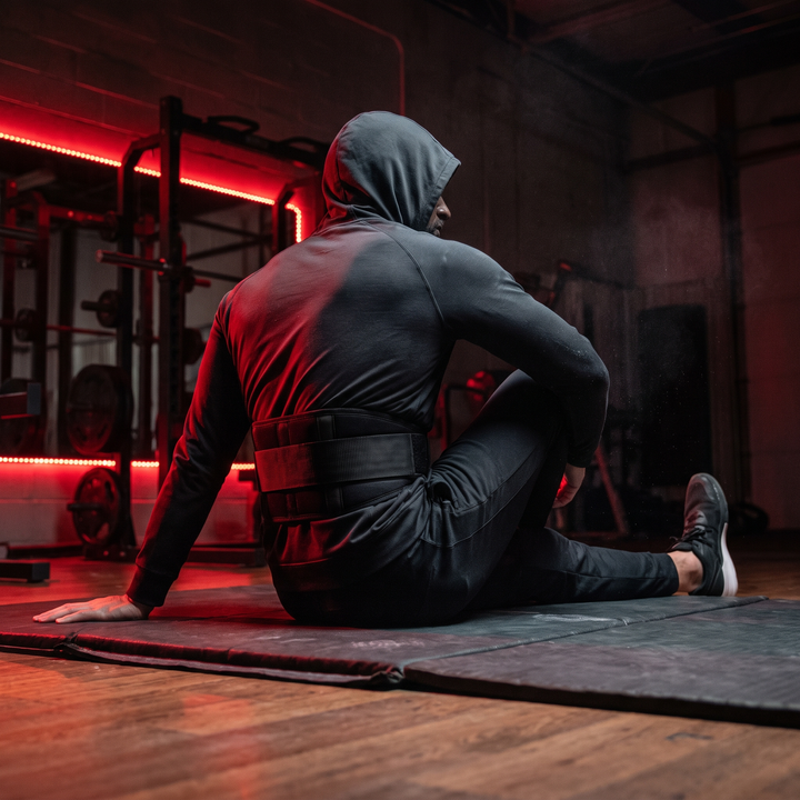 Person stretching their back while wearing a cordless waist recovery belt as part of a daily relaxation ritual