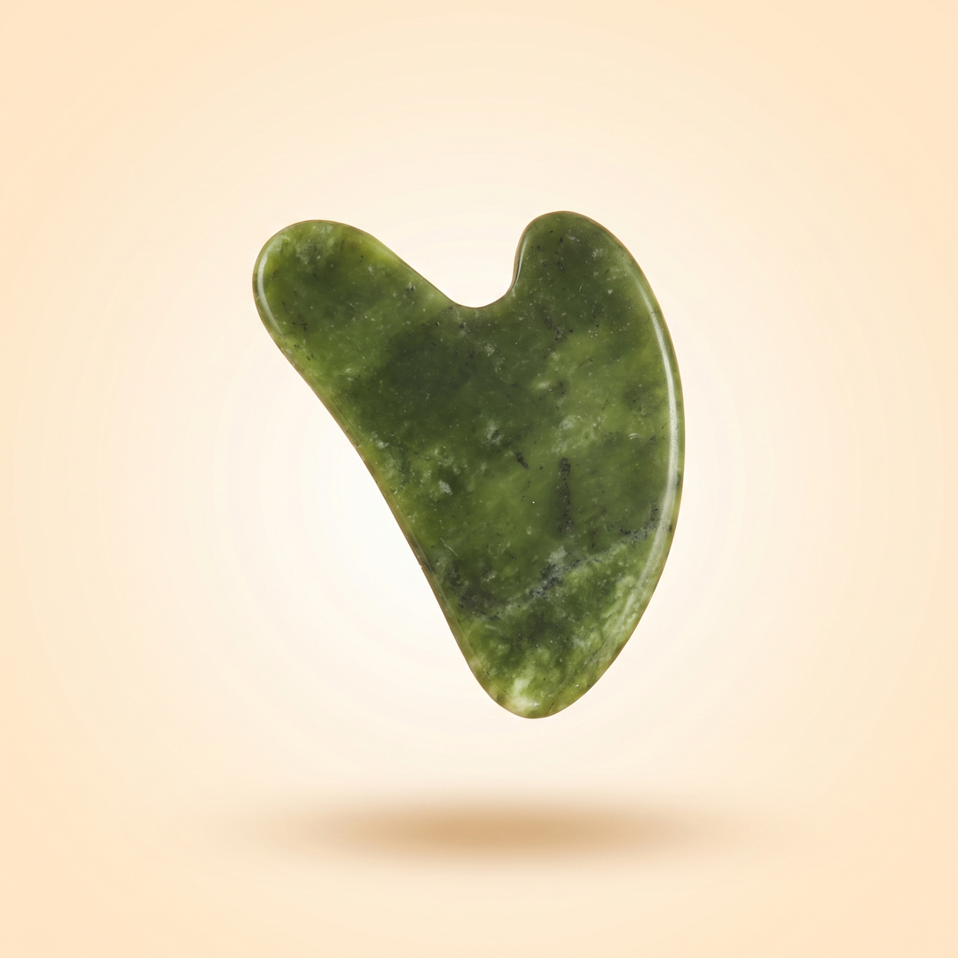 Jade gua sha beauty tool in a floating minimalist product composition
