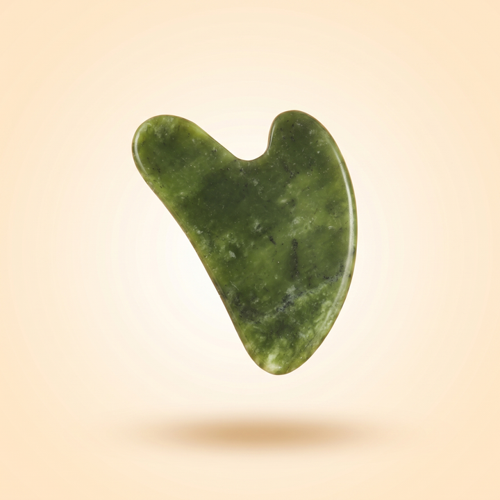 Jade gua sha beauty tool in a floating minimalist product composition