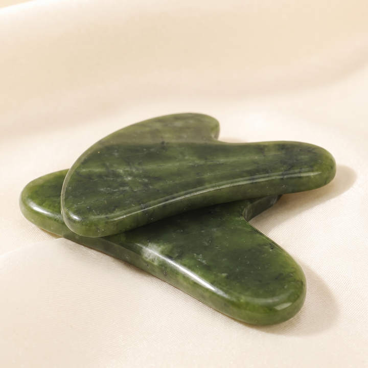 Side profile of jade gua sha tool showing curved contour edges