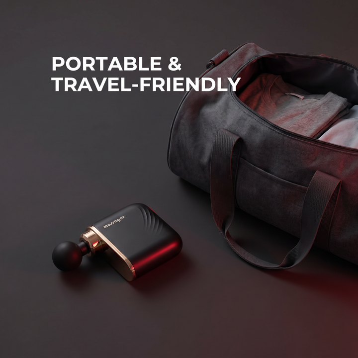 Portable travel-friendly mini massage gun next to travel bag