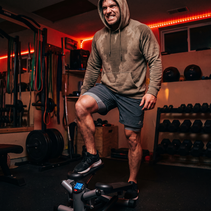 Heavy-Duty Mini Stepper with Resistance Bands LCD Monitor - lifestyle man mid-step cardio workout