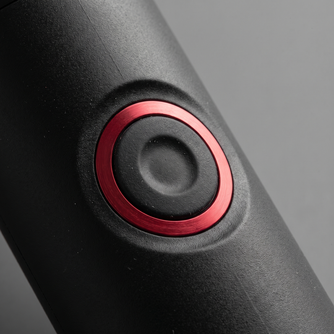 Close-up of the single control button on the PHYSIOATHLETX handheld muscle relaxation pen