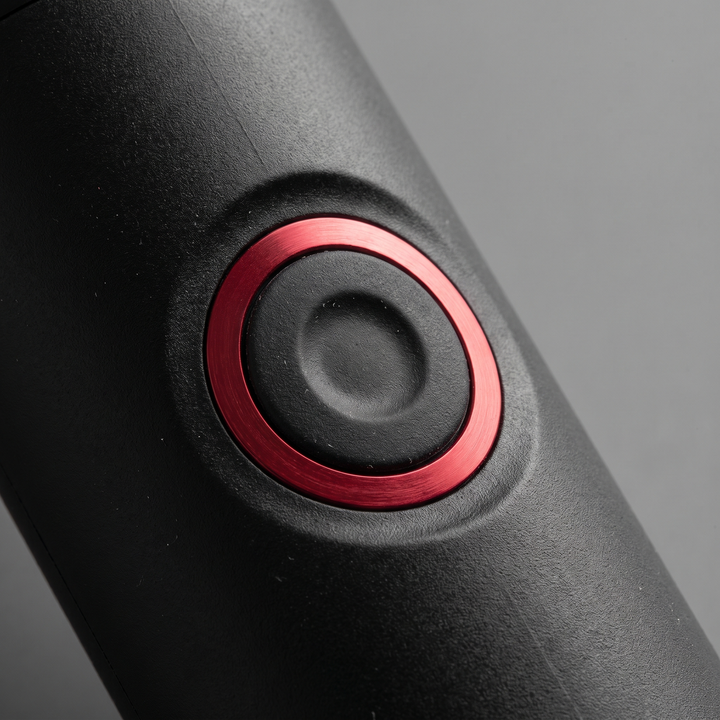 Close-up of the single control button on the PHYSIOATHLETX handheld muscle relaxation pen