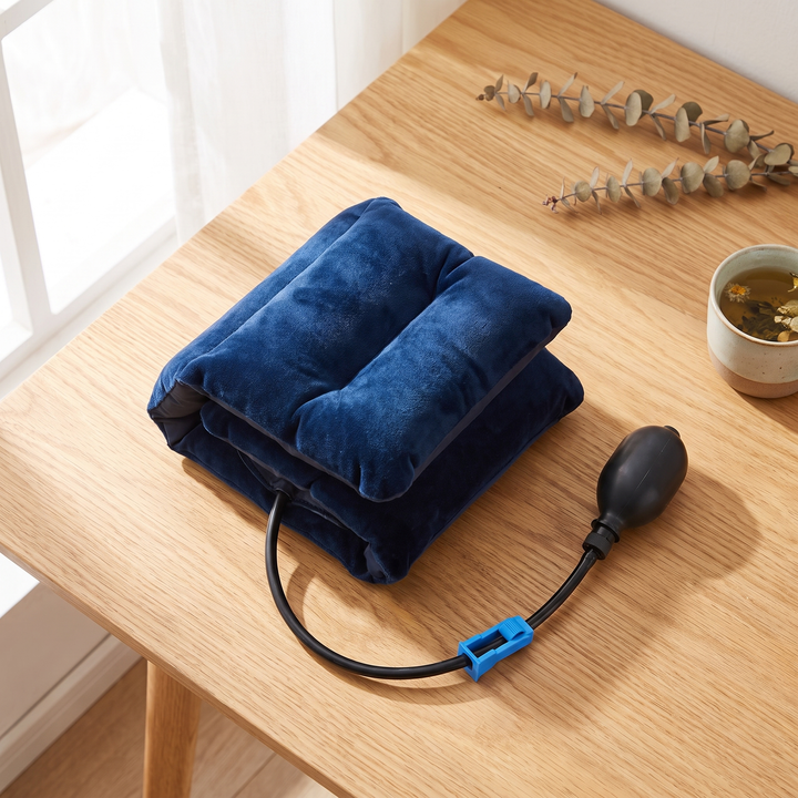 Blue inflatable neck relaxation cushion shown deflated and folded for compact storage