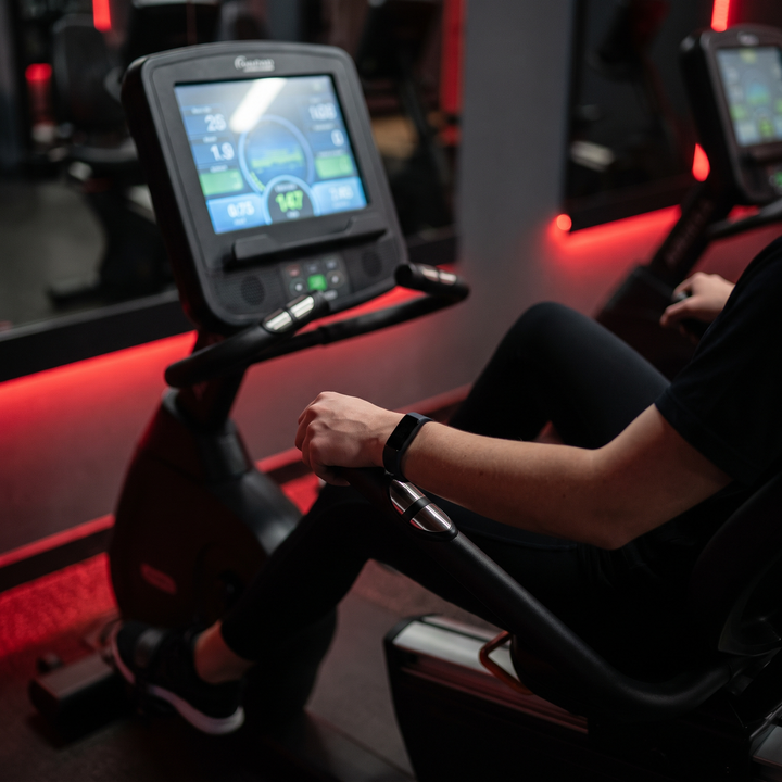 PhysioAthletX Adjustable Recumbent Exercise Bike - hands on heart rate monitor handlebar during workout