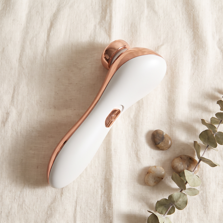 PHYSIOATHLETX radiofrequency beauty device, top-down flat lay on soft linen
