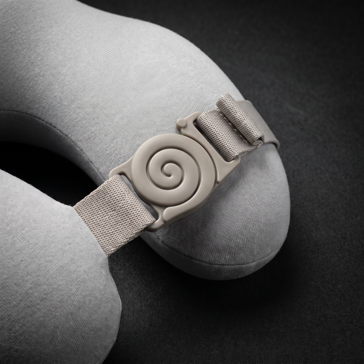 Adjustable wraparound clasp and strap on the light grey travel comfort pillow for a portable, adjustable fit