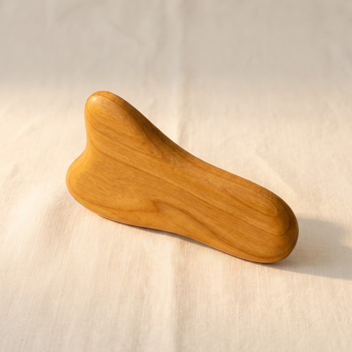 Wooden self-massage tool shown at an angle with ergonomic curves