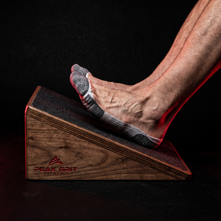 Feet secured on the non-slip surface of the PHYSIOATHLETX wooden incline board during a calf stretch