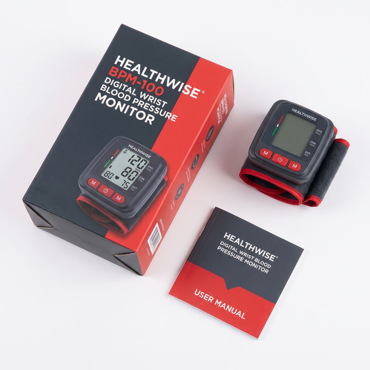 Packaging flat lay of digital wrist blood pressure monitor with cuff and manual
