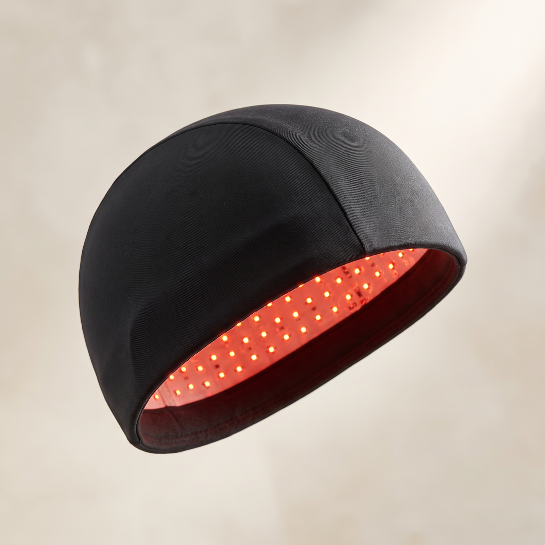 Black red light LED cap for scalp wellness rituals, front three-quarter view