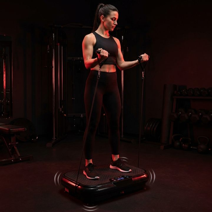 PHYSIOATHLETX vibration plate exercise machine - woman using resistance bands for full body vibration training